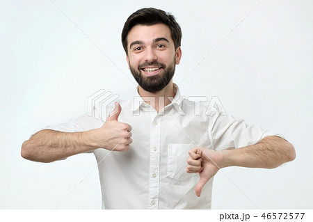 Man trying to make a desicion making good or bad sign. Man trying to make a desicion making good or bad sign. 46572577