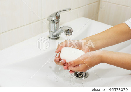 Washing of hands with soap under the crane  46573079