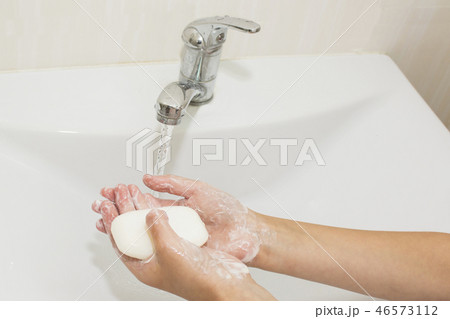 Washing of hands with soap under the crane  46573112