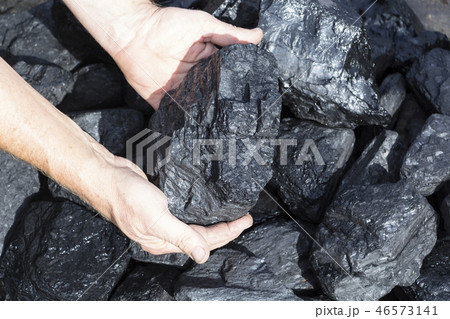 A man holding a piece of coal. A man holding a piece of coal. 46573141