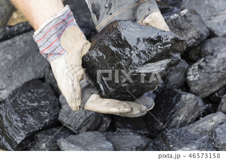 A man holding a piece of coal. A man holding a piece of coal. 46573158