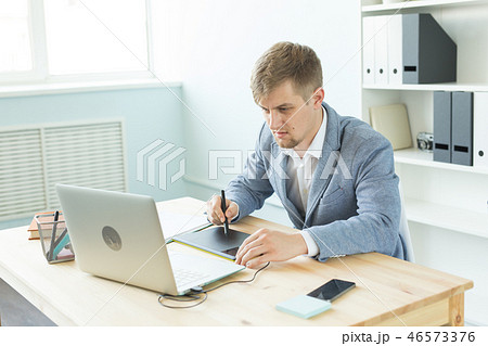 Designer, artist and web design concept - Portrait of young man using digital pen tablet and laptop Designer, artist and web design concept - Portrait of young man using digital pen tablet and laptop 46573376