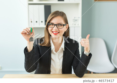 New home and real estate concept - Happy realtor woman giving you keys and showing thumb up 46573417