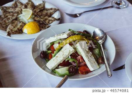 Small fried fish with lemon and Greek salad 46574081