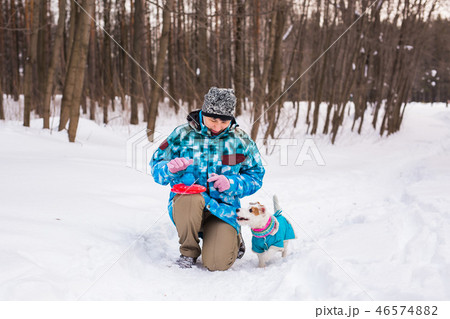 Middle aged woman outdoors with cute dog - Jack Russell Terrier in winter season 46574882