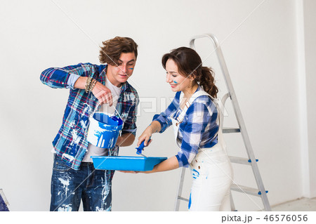 People, repair and renovation concept - Beautiful woman and handsome man paints the wall in new People, repair and renovation concept - Beautiful woman and handsome man paints the wall in new 46576056