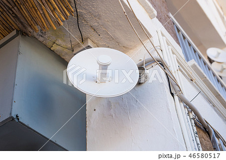 Satellite dish and TV antennas on the house roof with blue sky background. 46580517