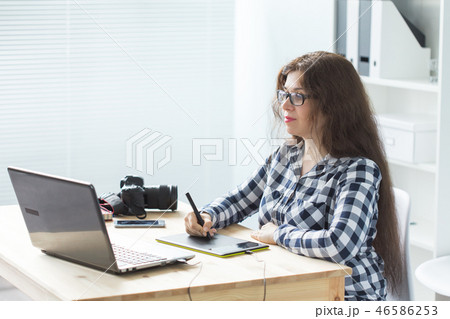 Working, business, technology and designer concept - young woman using tablet and watching in laptop 46586253