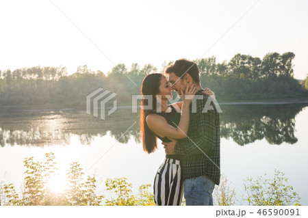People, love and nature concept - Portrait of young beautiful couple embracing each other over water People, love and nature concept - Portrait of young beautiful couple embracing each other over water 46590091