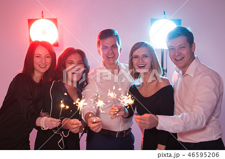 Celebrating with fun. Group of cheerful young men and women carrying sparklers. New year, holidays 46595206