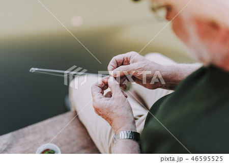 Aged angler putting the bait on the hook 46595525