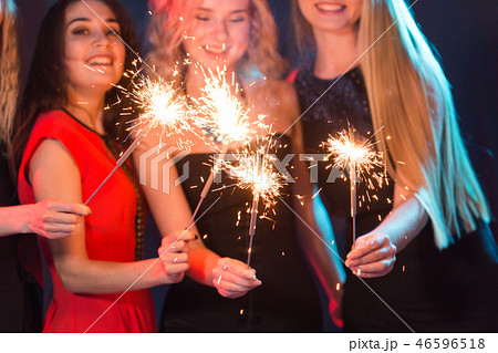 Celebrating with fun. Group of cheerful young women carrying sparklers. New year, holidays and party 46596518