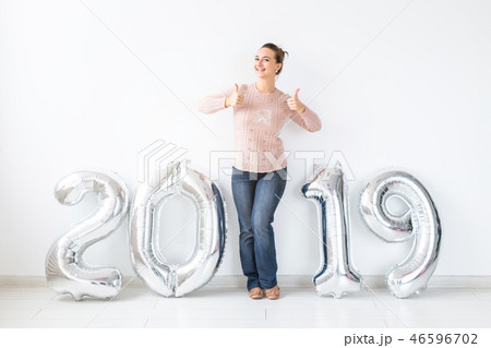 Party, holidays and people concept - Happy young woman celebrating New Year with big 2019 symbol and Party, holidays and people concept - Happy young woman celebrating New Year with big 2019 symbol and 46596702