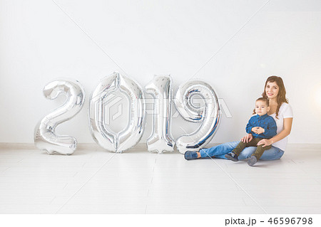 New 2019 Year is coming concept - Mother with her baby son sitting near silver colored numbers 46596798