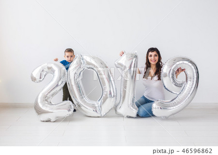 New 2019 Year is coming concept - Happy mother and son with silver colored numbers indoors. 46596862