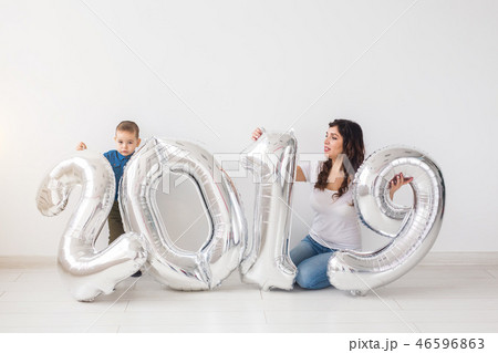 New 2019 Year is coming concept - Mother with her baby son sitting near silver colored numbers 46596863