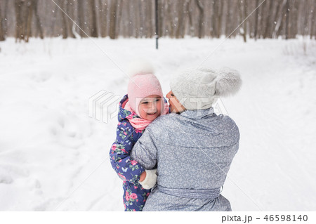 Family, children and nature concept - Young mother hug little happy child in the winter park 46598140