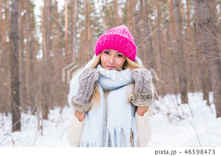 Beauty, winter and people concept - Attractive blonde woman in a pink sweater in the snowy forest is 46598473