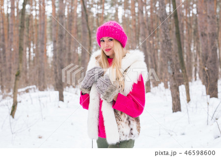 Nature, fashion and people concept - Young attractive blond woman posing in the winter park. 46598600