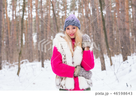 Nature, fashion and people concept - Young attractive blond woman posing in the winter park. 46598643