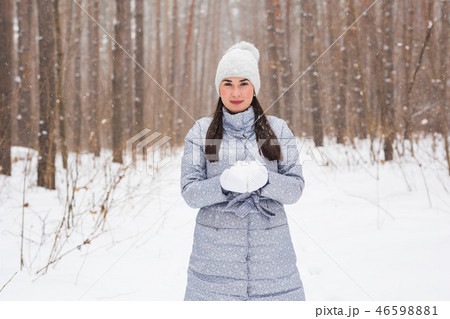 Christmas, holidays and season concept - Young beautiful smiling woman holding snow in hands in Christmas, holidays and season concept - Young beautiful smiling woman holding snow in hands in 46598881