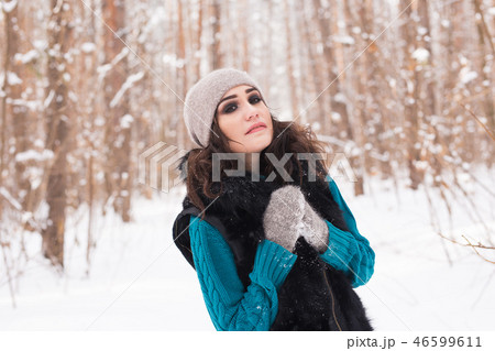 Young pretty woman walking in the winter snowy park at sunny day 46599611