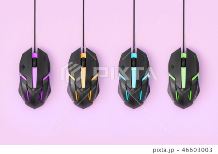 Black computer mouses hang on pink background Black computer mouses hang on pink background 46603003