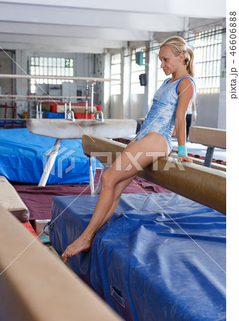 Mature sporty female gymnast in bodysuit during workout at broad bars Mature sporty female gymnast in bodysuit during workout at broad bars 46606888