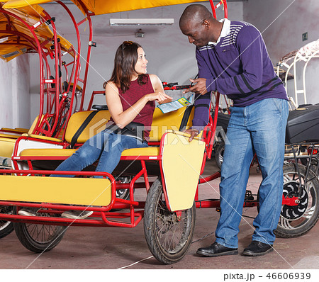 African American man driver of bikecab offering city tour to female 46606939