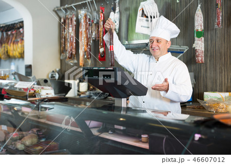 Salesman offering different sausages in market Salesman offering different sausages in market 46607012