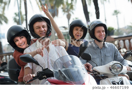 family of four sitting on scooter in city street family of four sitting on scooter in city street 46607199
