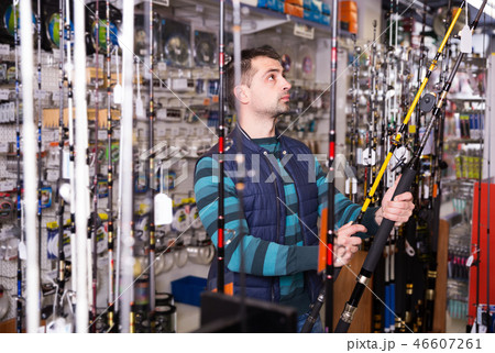 Fisherman customer choosing ocean fishing rod Fisherman customer choosing ocean fishing rod 46607261