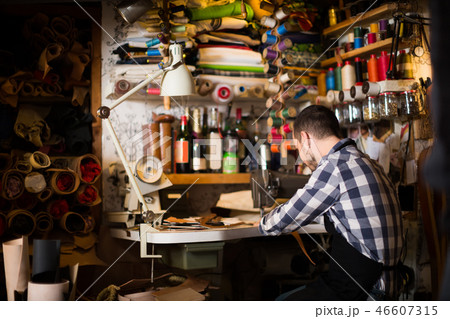 Attractive man worker working on stitches for belt Attractive man worker working on stitches for belt 46607315