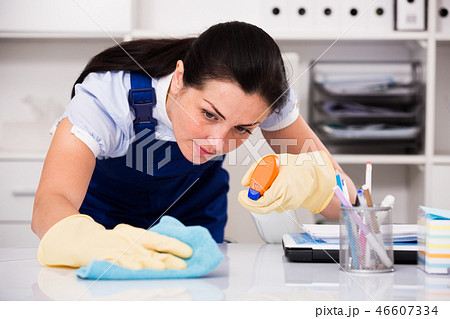 Young and smiling woman in gloves cleaning table Young and smiling woman in gloves cleaning table 46607334