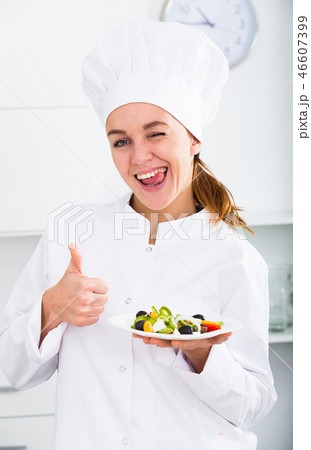 Girl cook shows plate of salad Girl cook shows plate of salad 46607399