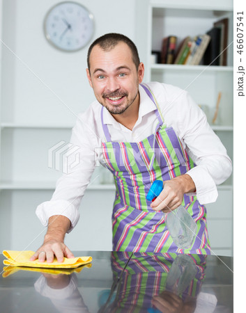 Young man in apron cleaning table Young man in apron cleaning table 46607541