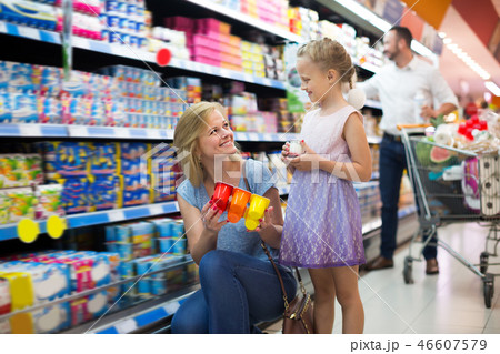 Adult woman and girl picking yogurt together Adult woman and girl picking yogurt together 46607579