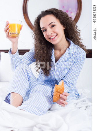 Adult girl eating pastry and juice in bed Adult girl eating pastry and juice in bed 46607838