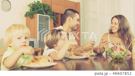 Family of four eating spaghetti Family of four eating spaghetti 46607852