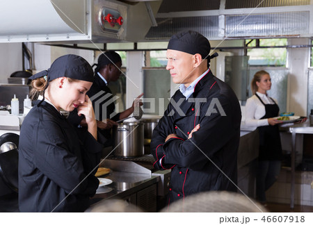 Exasperated chef scolding female employee Exasperated chef scolding female employee 46607918