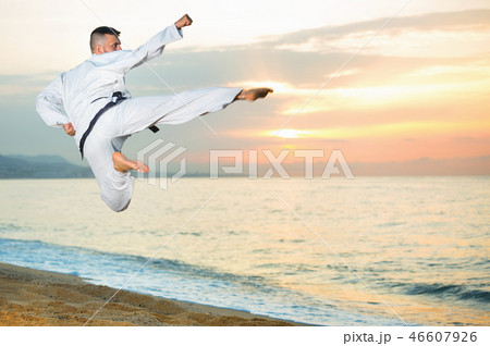 Guy doing karate poses at sunset sea shore Guy doing karate poses at sunset sea shore 46607926