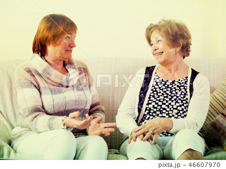 Female pensioners discussing something and laughing indoors 46607970
