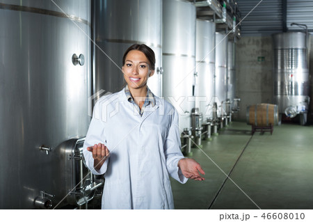 Female in uniform standing in winery compartment Female in uniform standing in winery compartment 46608010