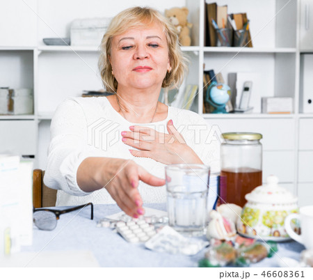 Mature woman with medicines and bills 46608361