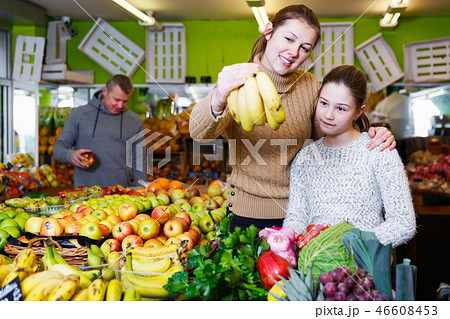 girl with mother choosing fresh ripe fruits 46608453