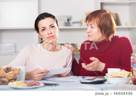Sad young female and mother with financial documents 46608496
