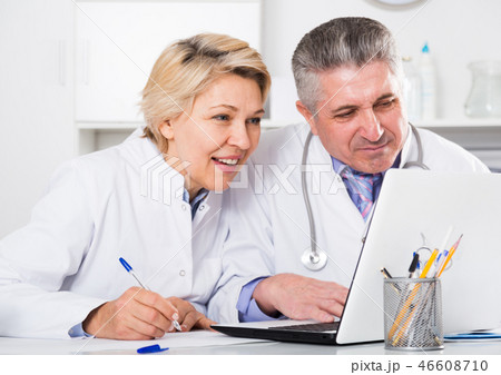 Doctor and nurse reading information 46608710