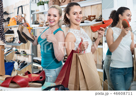 Two girls holding a paper shopping bags in the boutique 46608711