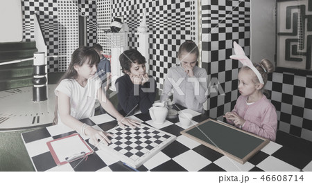 children discuss the game in the chess quest room 46608714