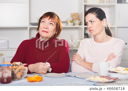 Unhappy adult female quarrel with daughter at table Unhappy adult female quarrel with daughter at table 46608718